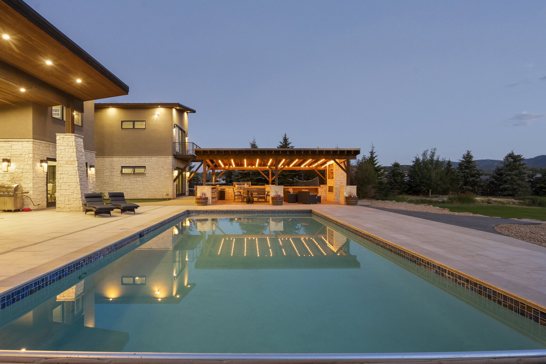 Rectangular swimming pool with tiled coping, surrounded by an expansive concrete patio