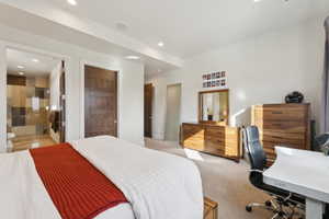 Carpeted bedroom featuring an en-suite bathroom with a glass-enclosed shower, mosaic tile wall, and light-toned floor tiles