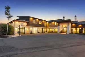 Expansive driveway fronting a modern exterior with stone and wood-paneled accents