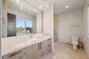 Contemporary bathroom featuring a wood-finish double vanity with integrated rectangular sinks and stone-look countertops