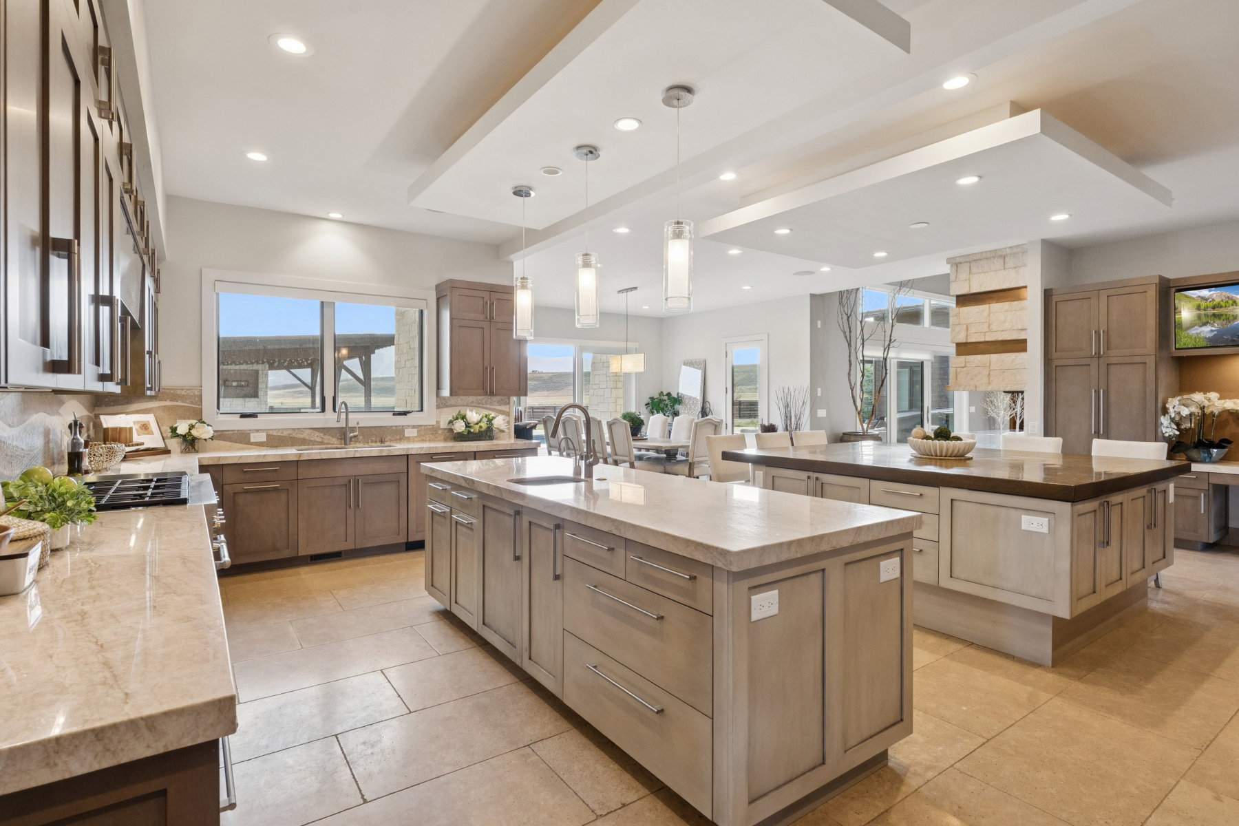 Spacious kitchen featuring two large islands with stone countertops, integrated sink, and ample cabinetry