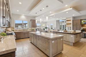 Spacious kitchen featuring two large islands with stone countertops, integrated sink, and ample cabinetry