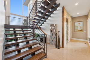 Open riser staircase with wood-finish treads and metal railing