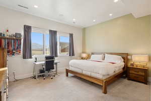 Bedroom featuring a large window, recessed ceiling lighting, light-colored carpeting, a wall-mounted speaker, and a wall-mounted vent