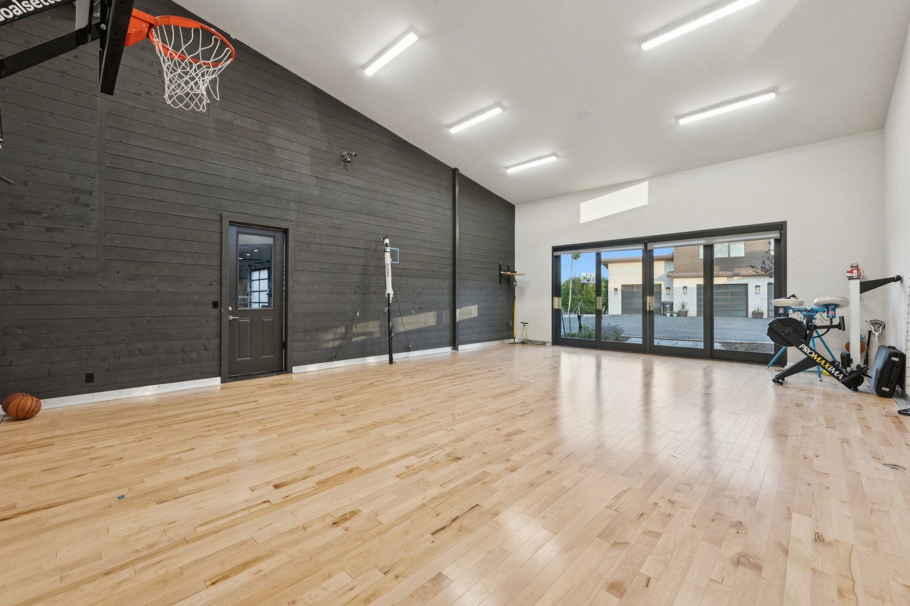 Spacious indoor recreation area with light wood-finish flooring