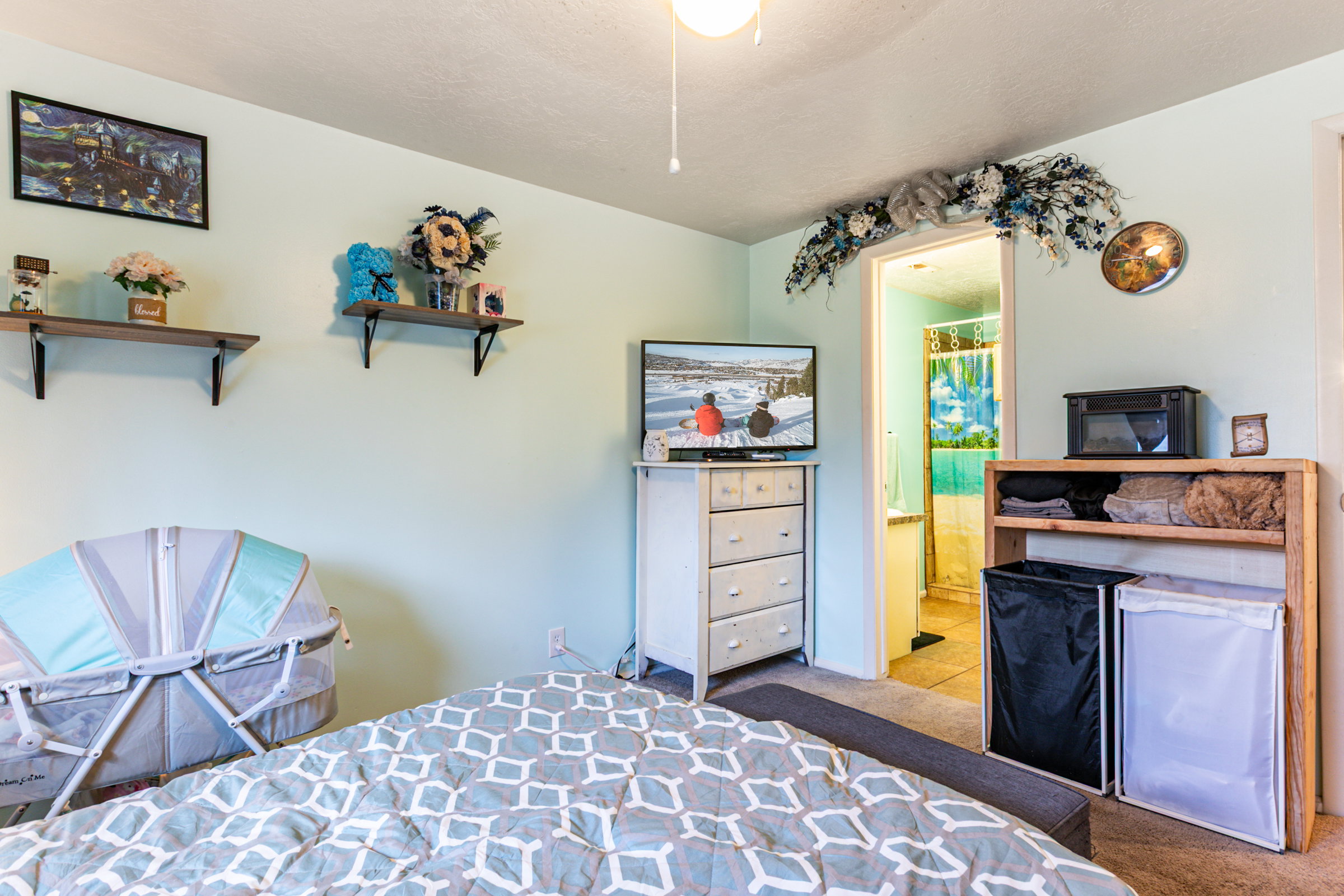 Bedroom space featuring light blue walls and a ceiling fan
