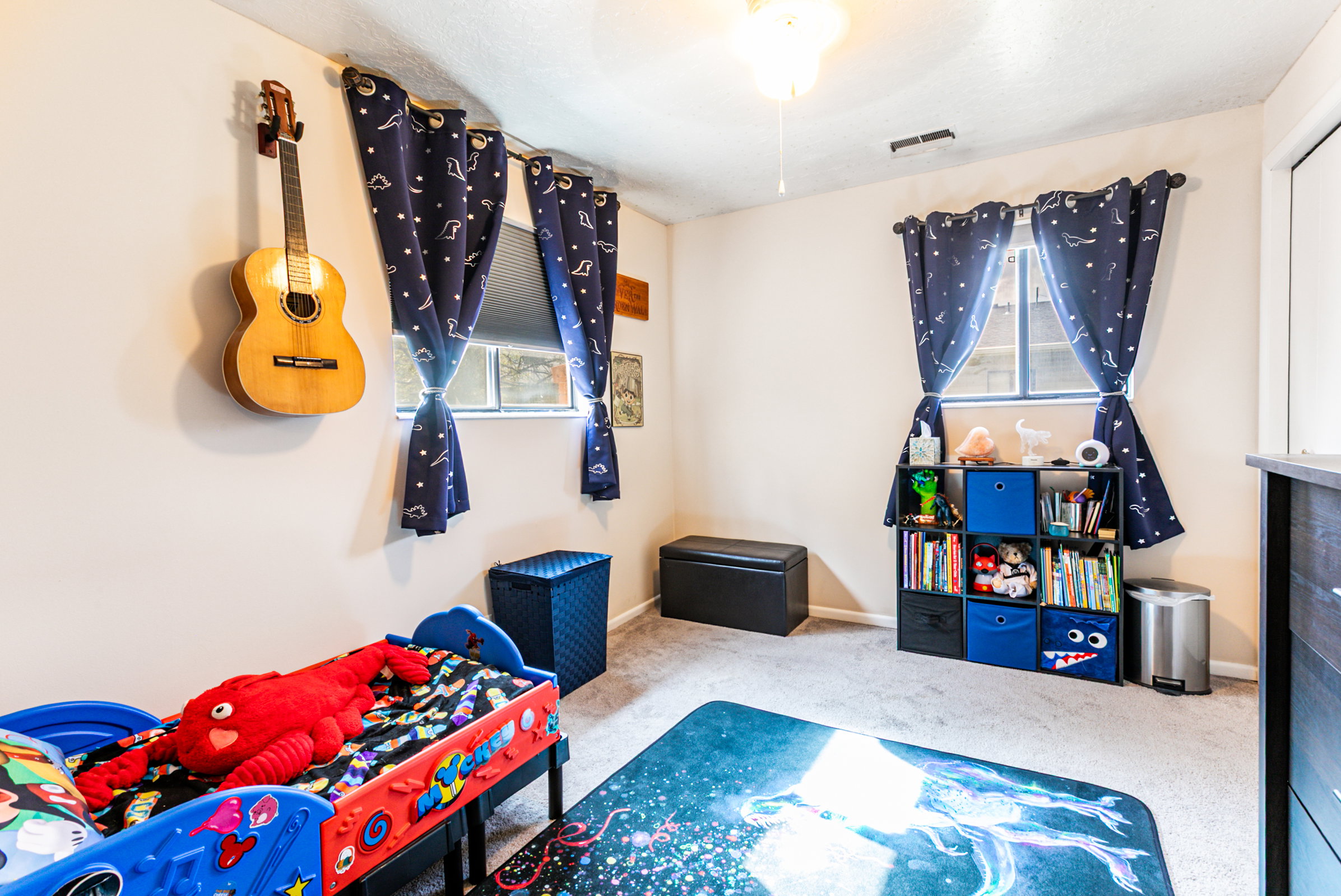 Carpeted room featuring light-colored walls and a ceiling fan with integrated lighting