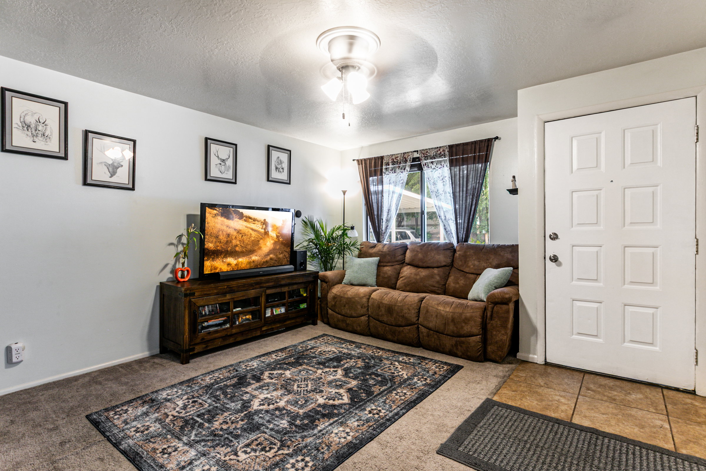 Living area featuring light-colored walls and carpeted flooring