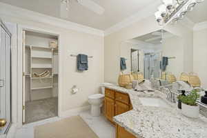 Bathroom featuring a dual vanity with granite-style countertops, wood cabinetry, and a mirrored wall
