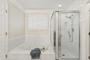 Soaking tub with white tile surround and plantation shutters