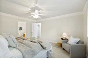 Spacious bedroom featuring light-toned walls, crown molding, and a ceiling fan with integrated lighting