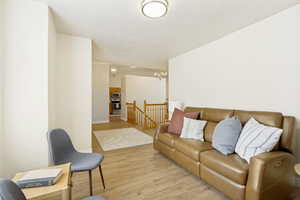 Open living area featuring wood-finish flooring, a neutral color palette, and a flush-mount ceiling light