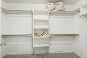 Custom closet system featuring shelving, multiple hanging rods, and an integrated vertical storage unit