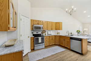Kitchen featuring wood cabinetry, stainless steel appliances, white subway tile backsplash, and light-toned countertops
