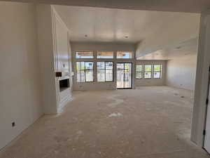 Spacious main living area featuring a built-in fireplace with a mantel, recessed lighting, expansive windows, and a sliding glass door