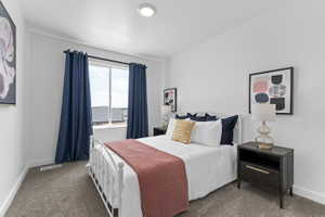 Bedroom featuring a window with broad white trim, recessed lighting, neutral carpet flooring, and white baseboards