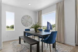 Dining space featuring wood-finish flooring, recessed lighting, and white walls