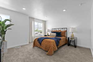 Carpeted bedroom featuring white walls, recessed lighting, and dual windows
