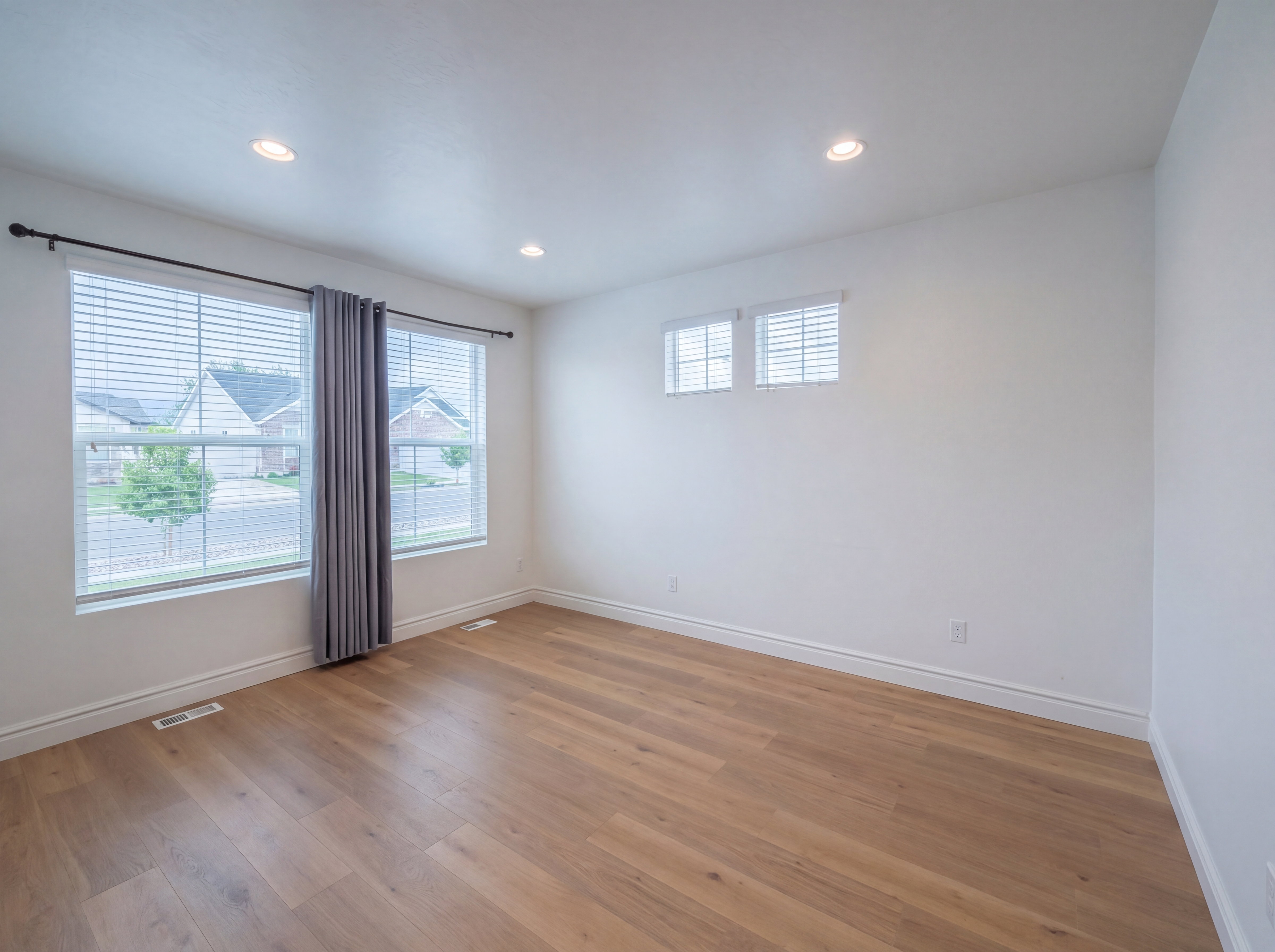 Bright room featuring wood-finish flooring and recessed ceiling lights