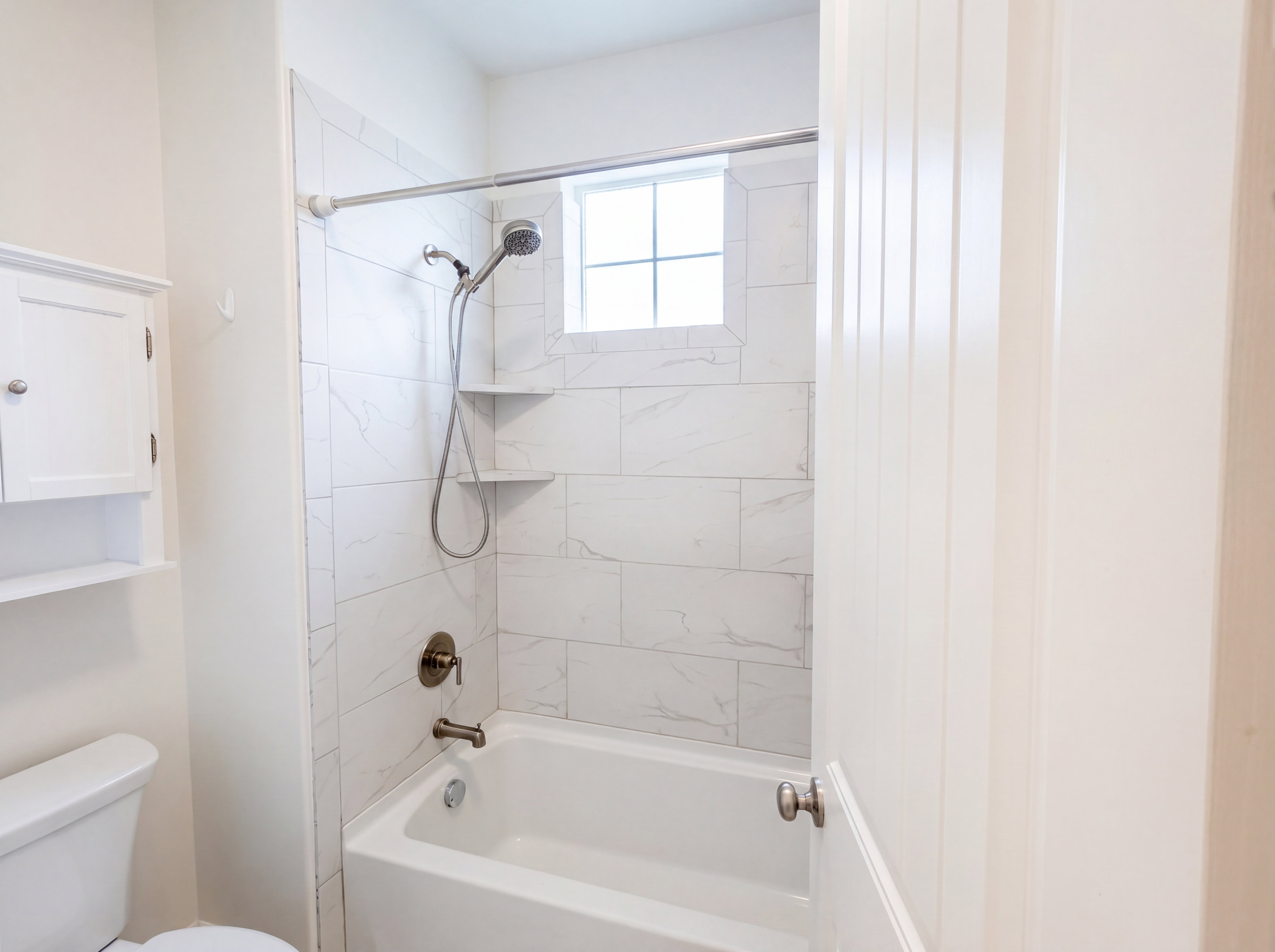 Shower-over-tub combination with white subway tile surround, integrated corner shelves, and a window for natural light