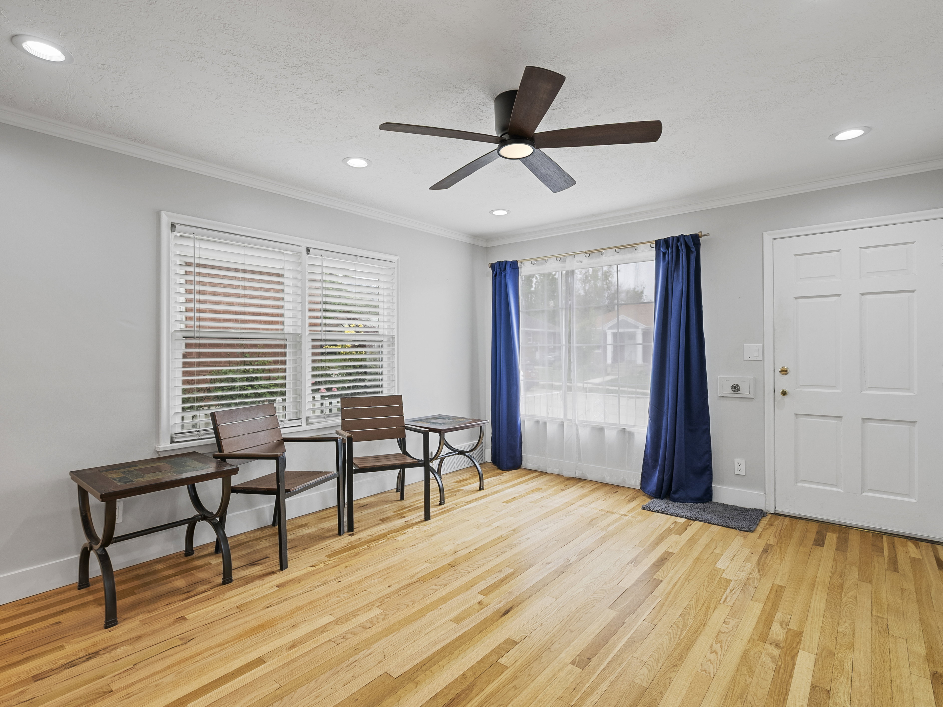 Open concept living space featuring wood-finish flooring, crown molding, and recessed lighting