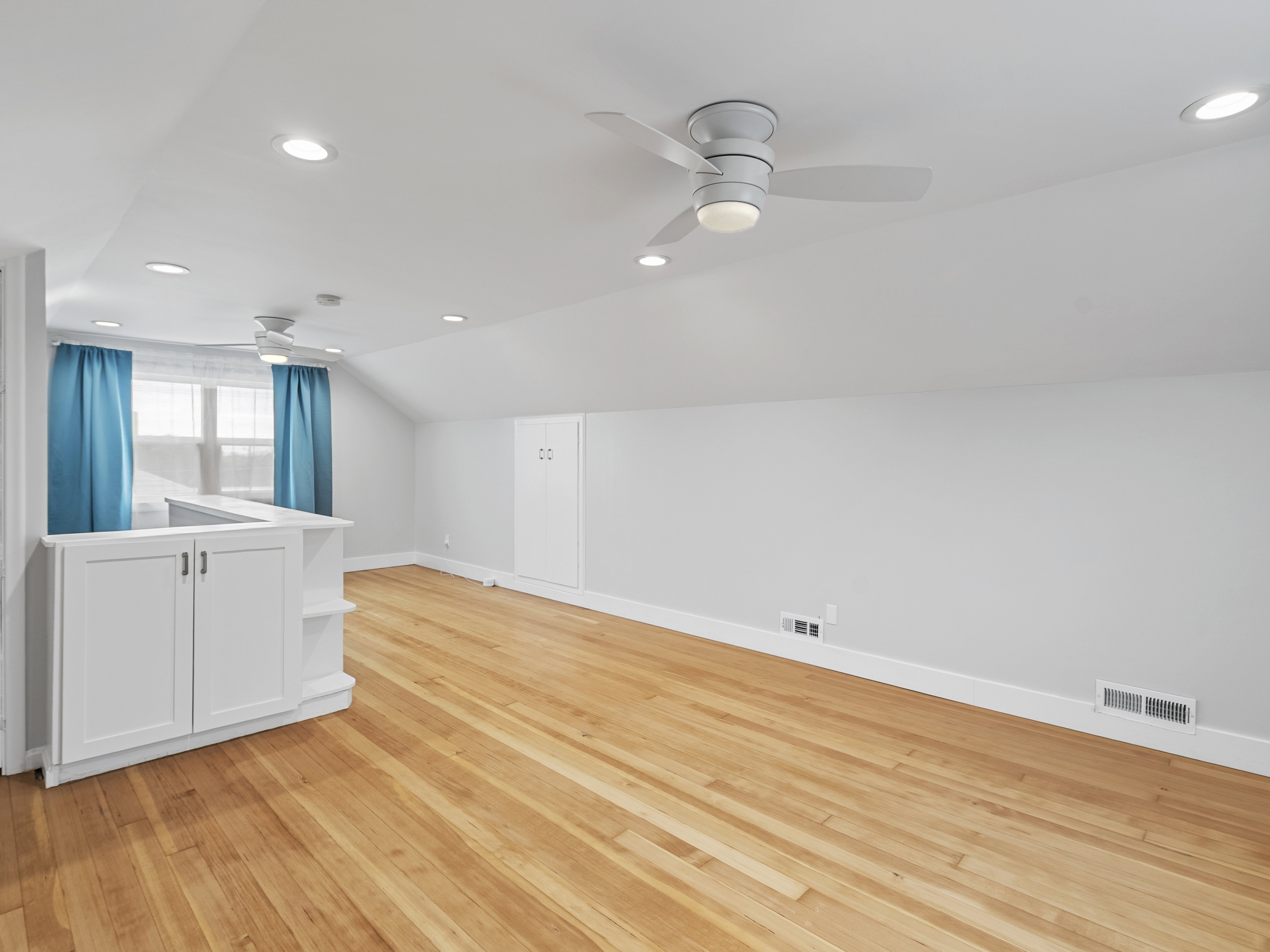 Hardwood flooring with white baseboards and neutral wall paint