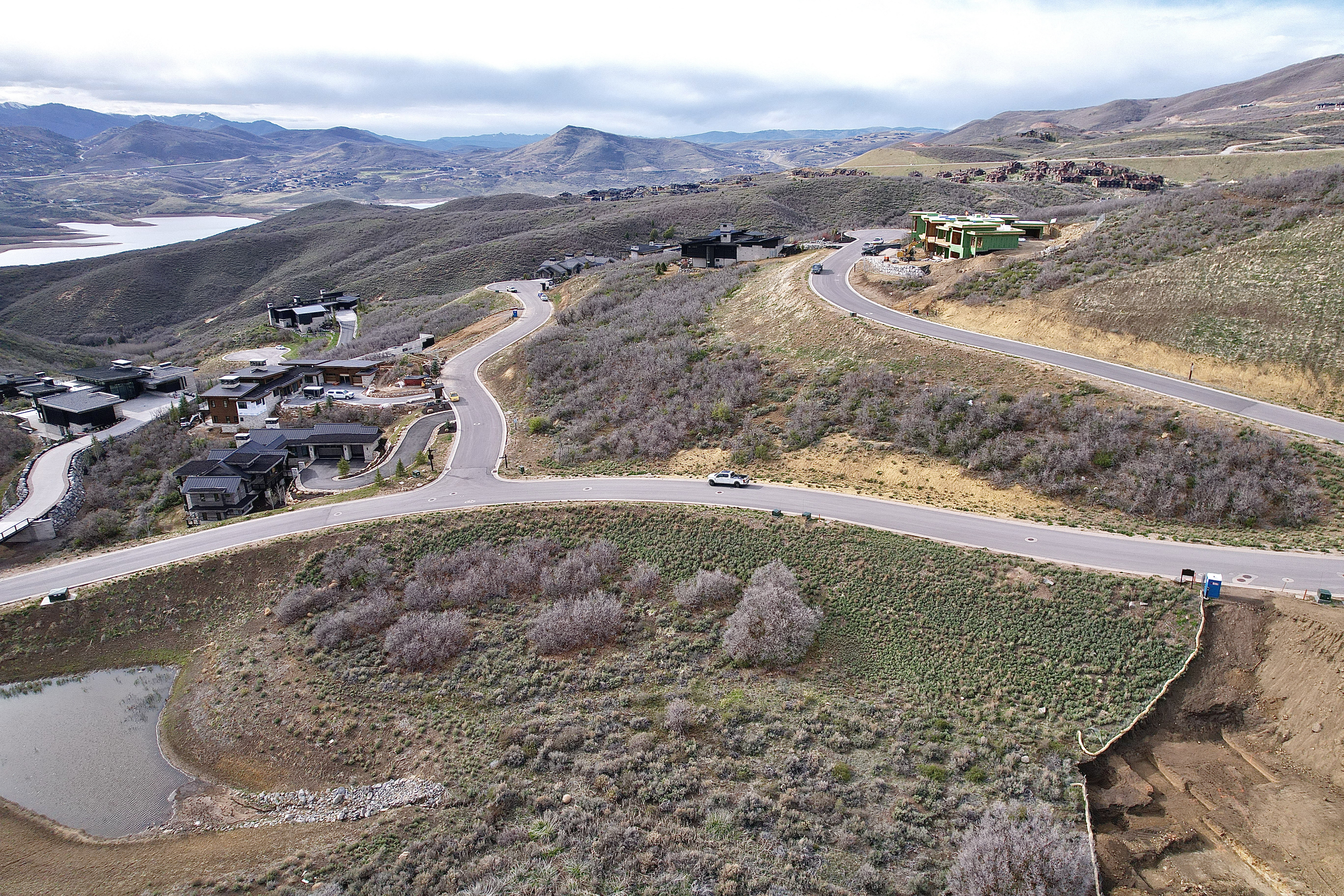 Hillside property featuring paved roads, established homes, and undeveloped lots