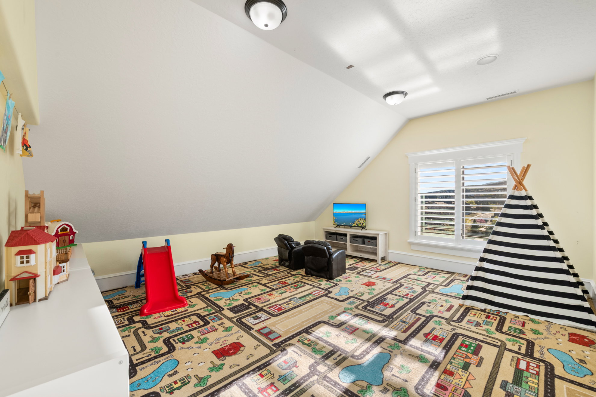 Attic room featuring a sloped ceiling, light yellow walls, and recessed lighting