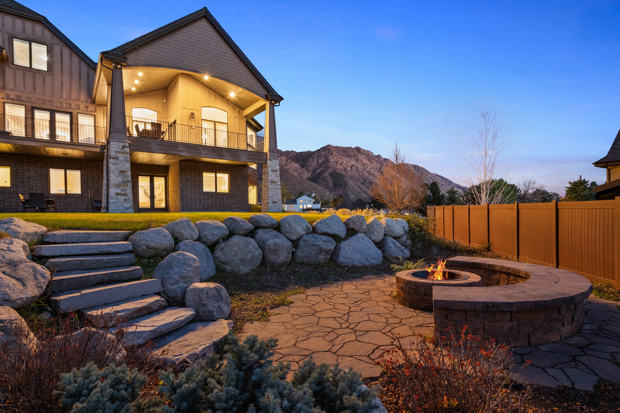 Stone patio featuring a built-in fire pit with a curved seating wall