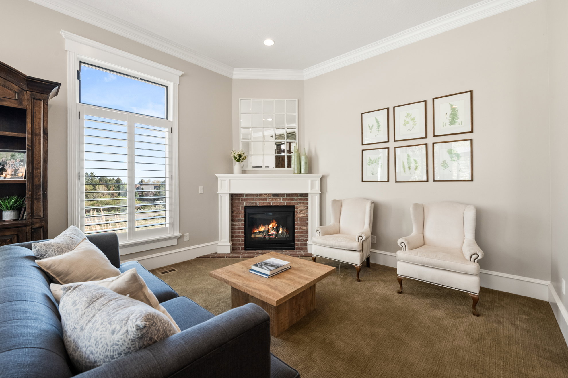 Corner fireplace with brick surround, white mantel, and hearth