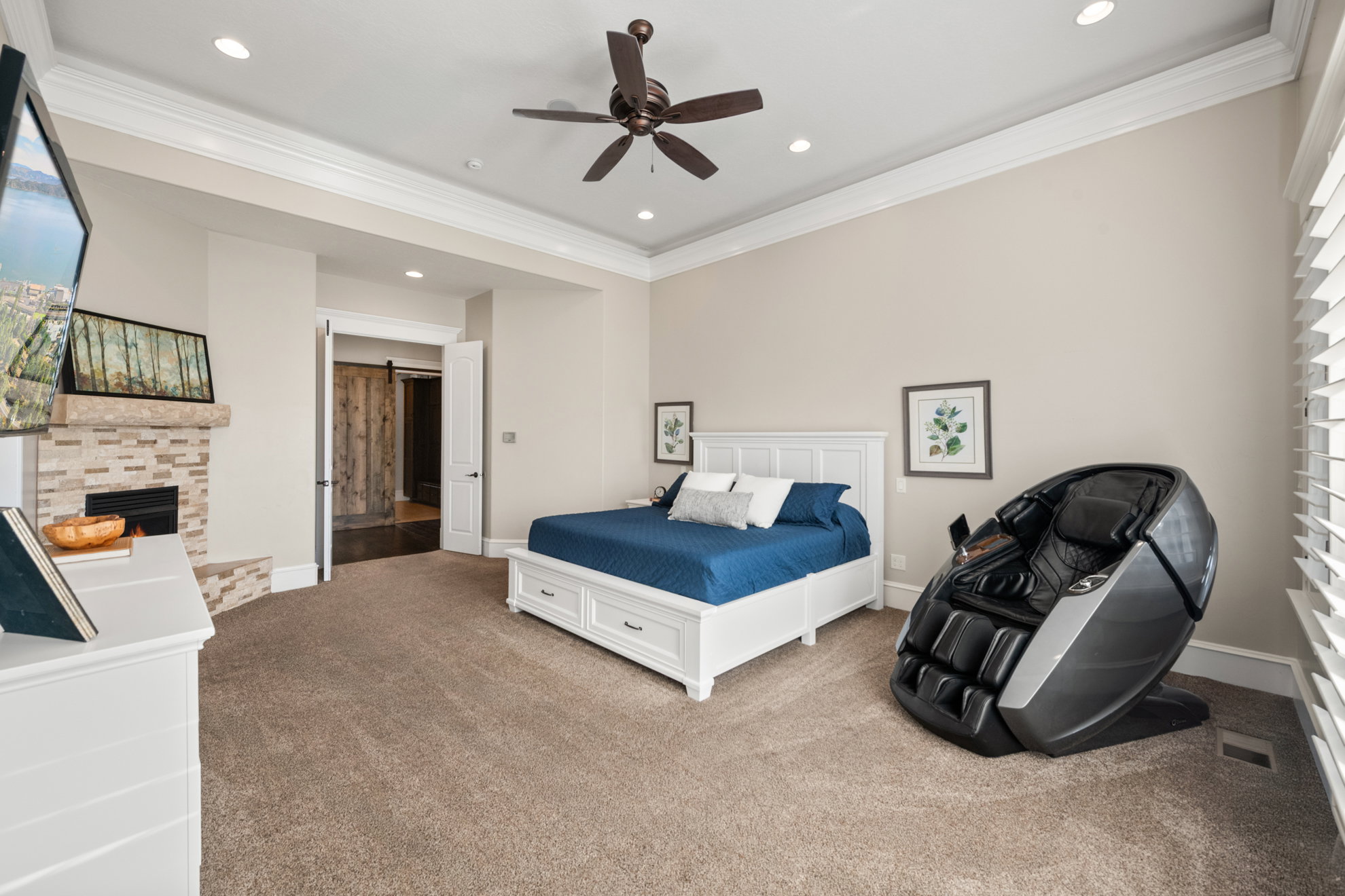 Spacious room featuring tray ceiling, recessed lighting, fireplace with stone surround, and carpet flooring