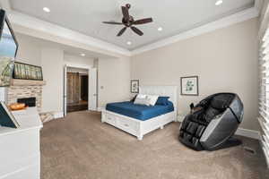 Spacious room featuring tray ceiling, recessed lighting, fireplace with stone surround, and carpet flooring