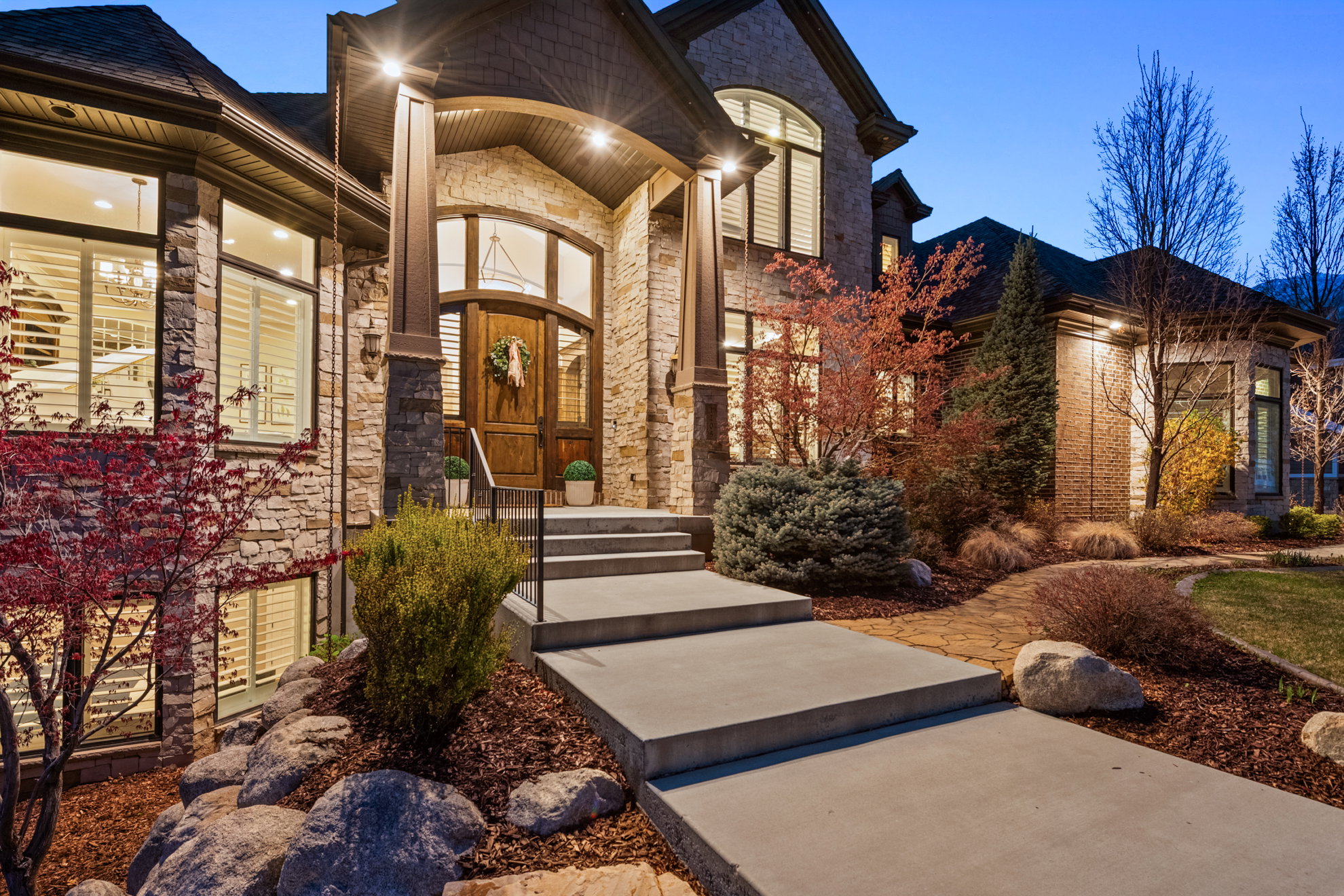Stone and siding exterior with a prominent arched wooden entry door