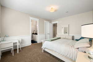 Carpeted room featuring wainscoting, crown molding, and a recessed ceiling speaker