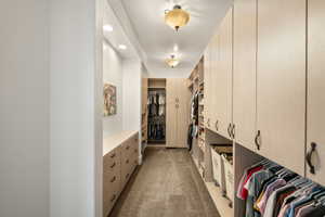 Custom walk-in closet featuring extensive built-in cabinetry, integrated drawers, recessed lighting, and ceiling-mounted fixtures