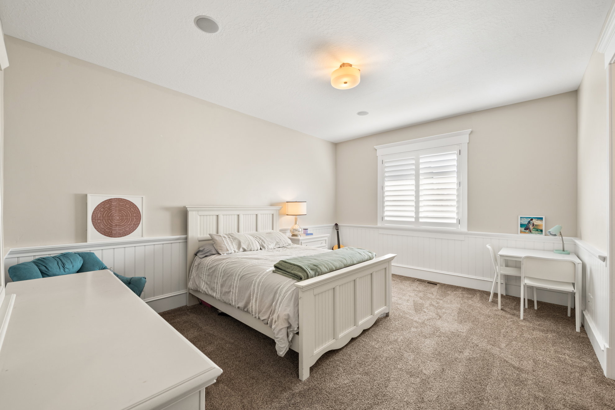 Carpeted room featuring wainscoting, white trim, a window with plantation shutters, and recessed ceiling lighting