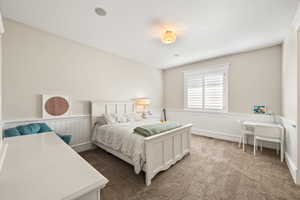 Carpeted room featuring wainscoting, white trim, a window with plantation shutters, and recessed ceiling lighting