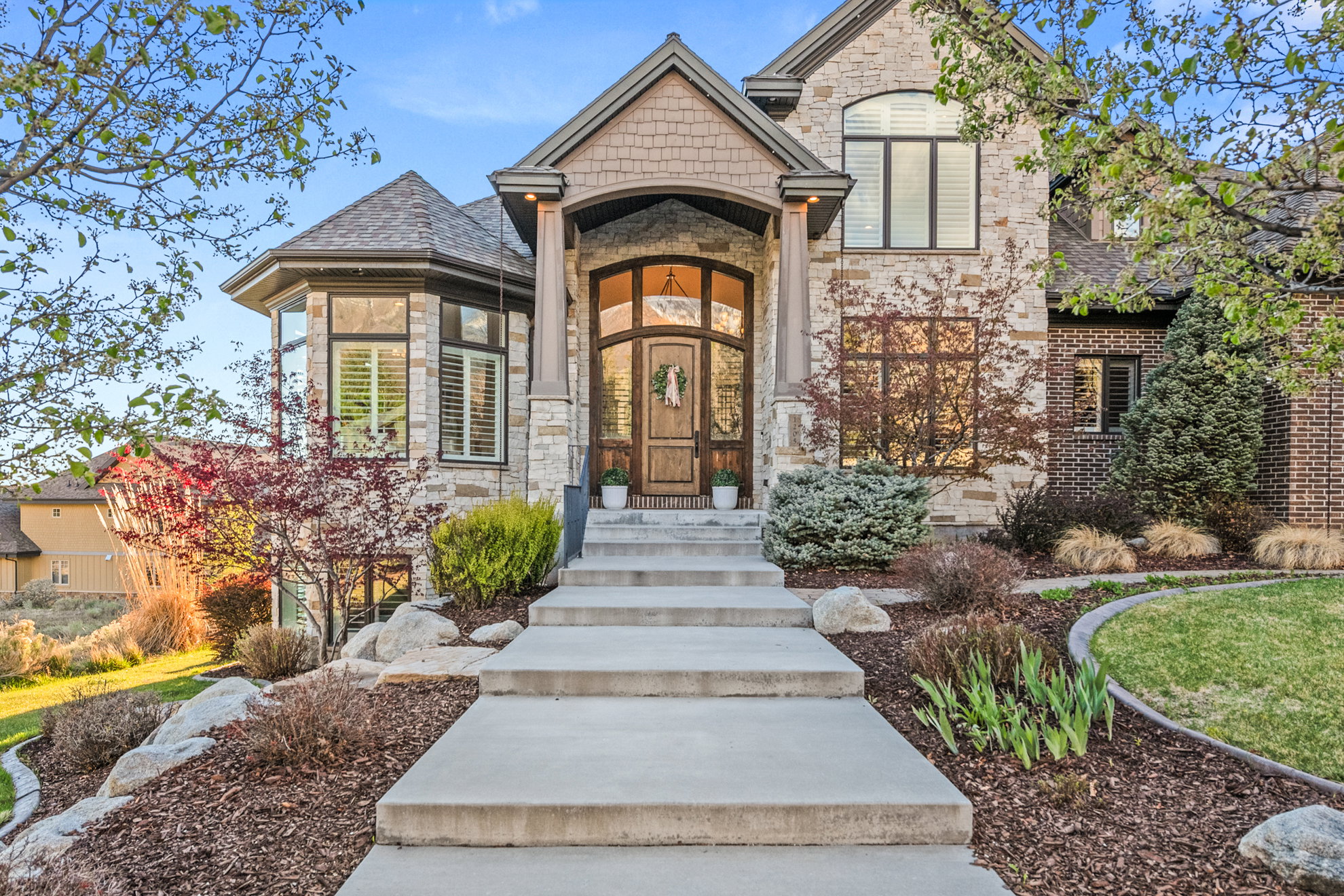 Stone and brick exterior with a prominent arched entry and decorative wood door