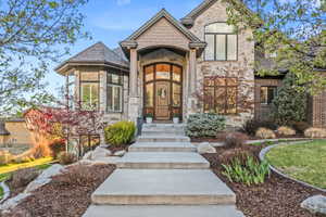 Stone and brick exterior with a prominent arched entry and decorative wood door