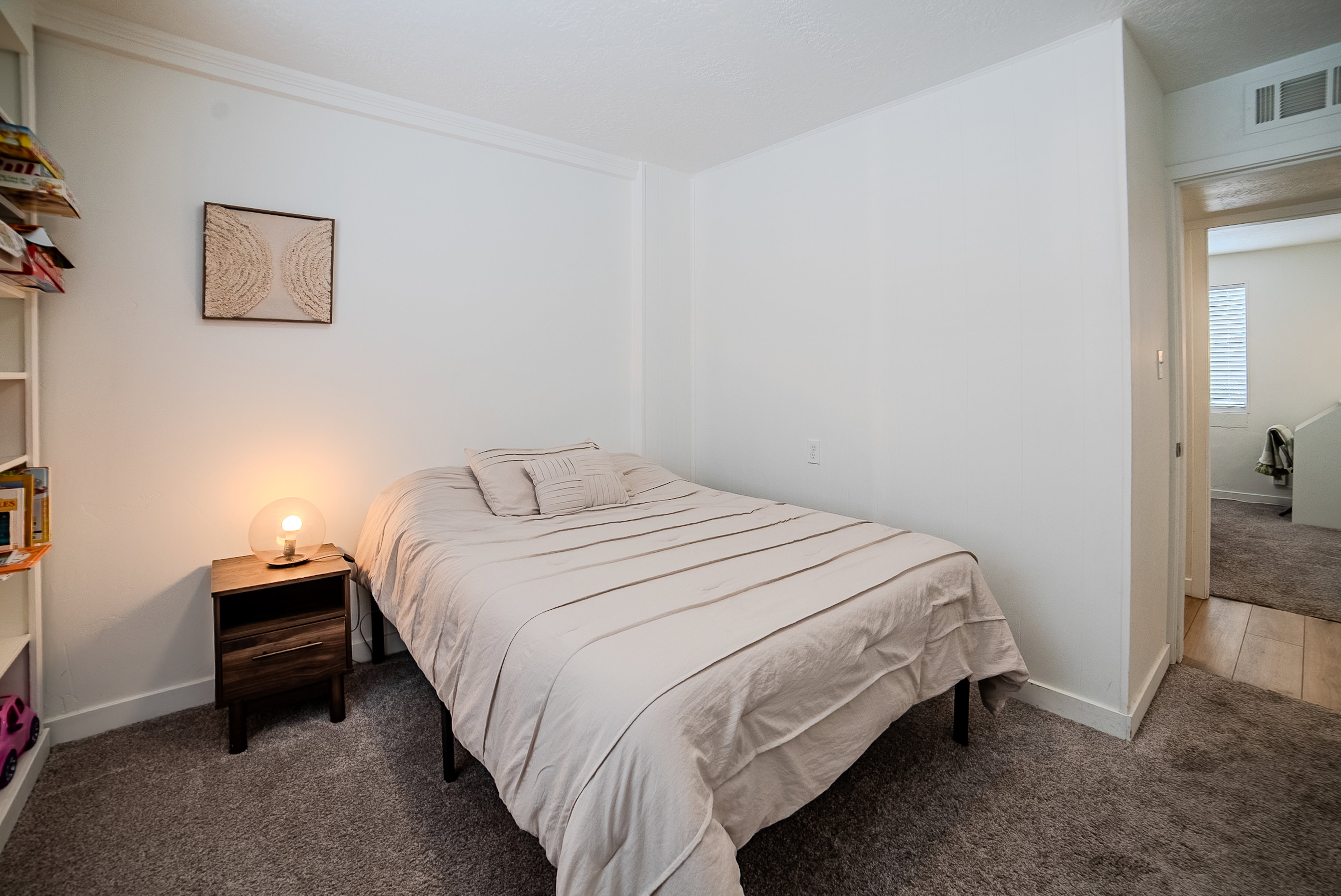 Carpeted room featuring white walls, white baseboards, and crown molding