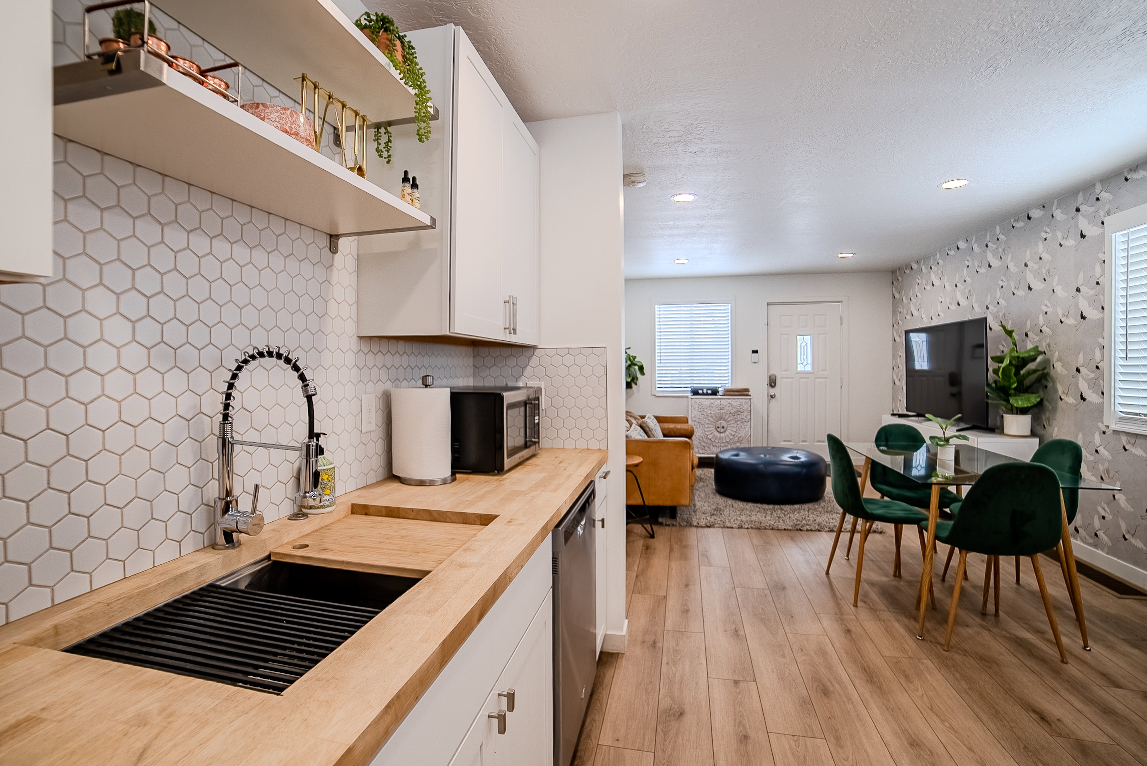 Kitchen features include a honeycomb tile backsplash, wood-finish countertops, and white upper and lower cabinetry