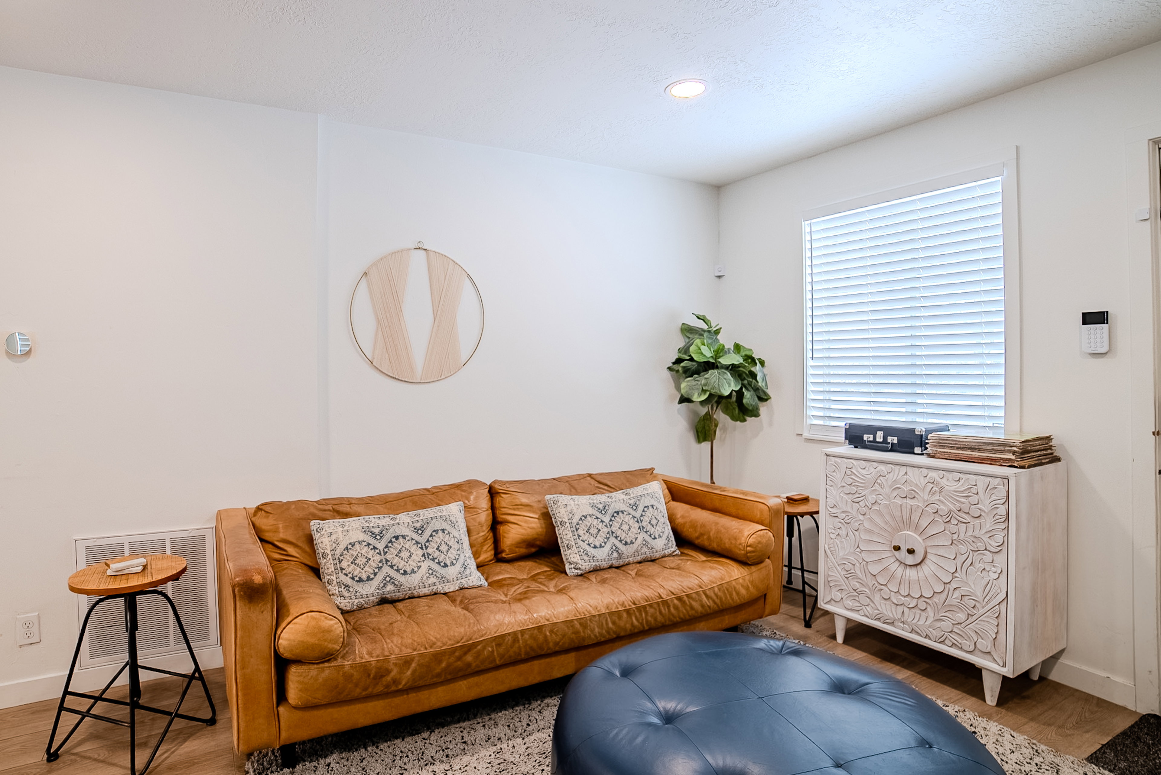 Bright room featuring a window with horizontal blinds, recessed ceiling lighting, wood-finish flooring, and a floor vent
