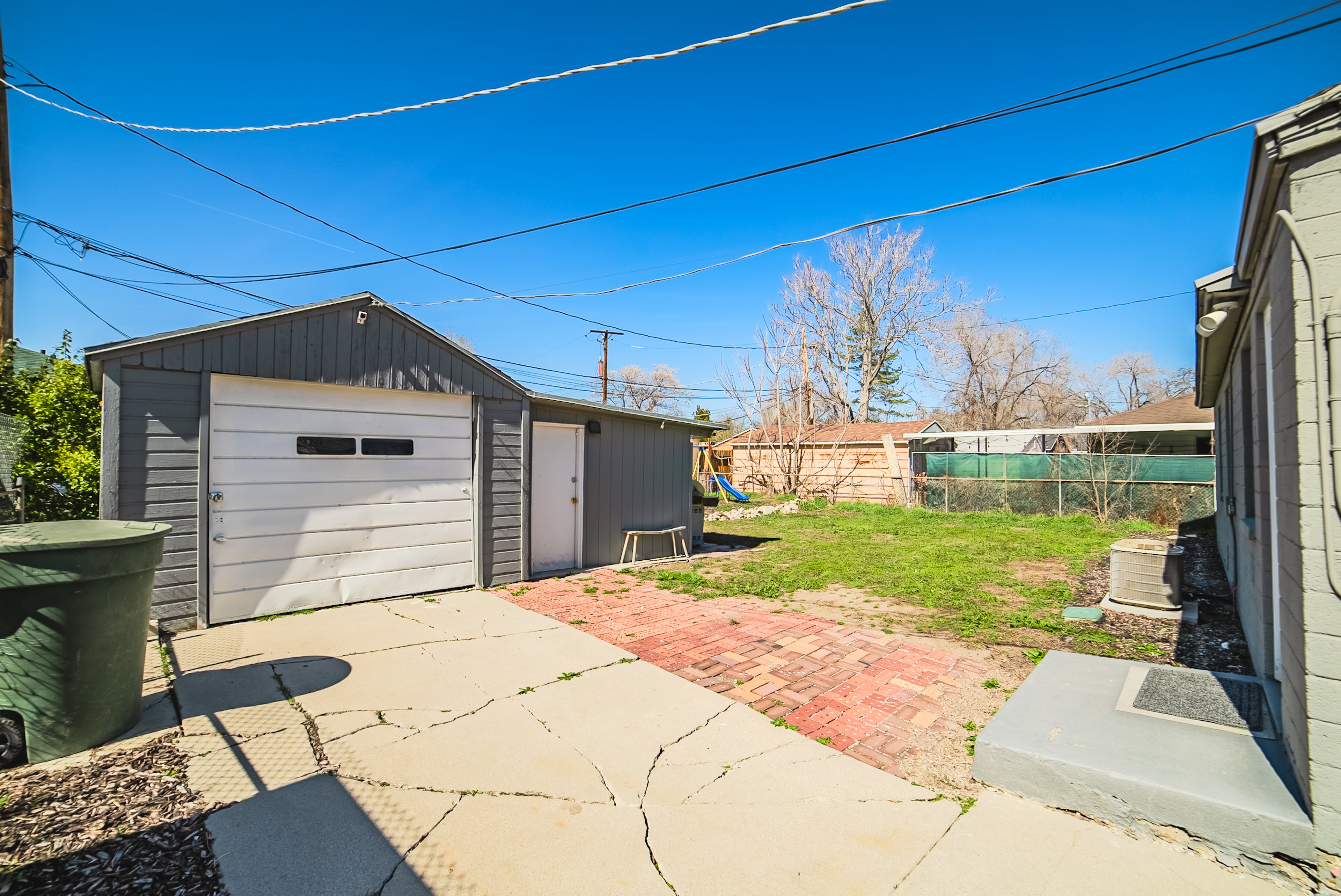 Detached garage structure with a white overhead door and side entry