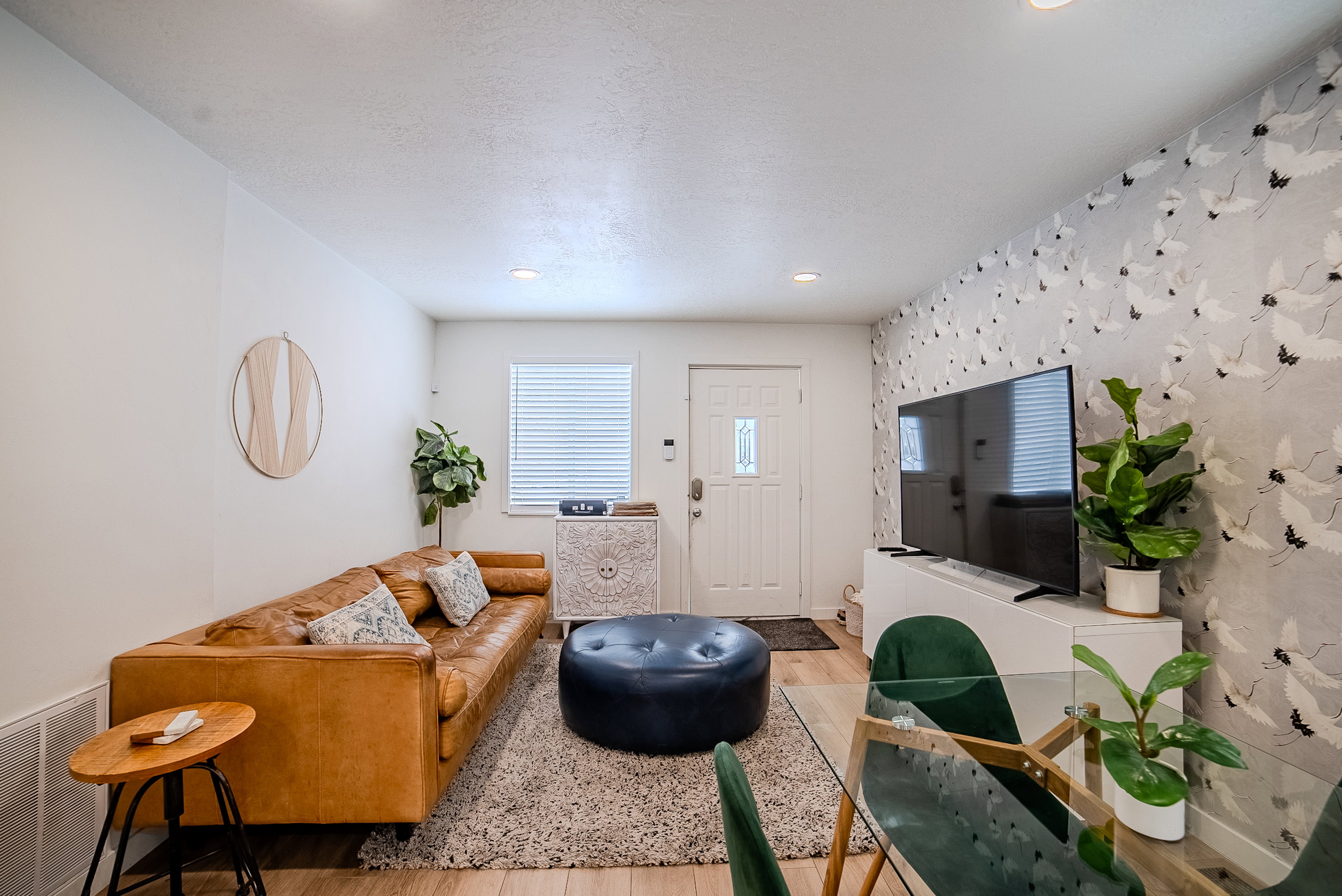 Living area featuring wood-finish flooring, recessed lighting, and a textured accent wall