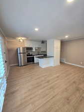Open-concept living space with wood-finish flooring