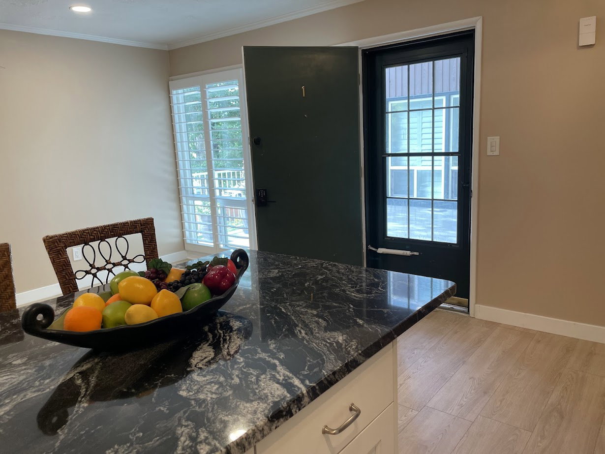 Kitchen island with a dark granite-style countertop and light-colored cabinetry