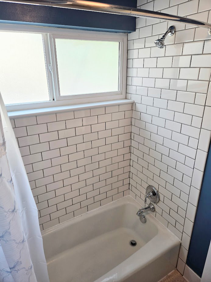 White subway tile bath surround featuring a built-in tub with chrome fixtures