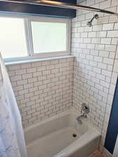 White subway tile bath surround featuring a built-in tub with chrome fixtures