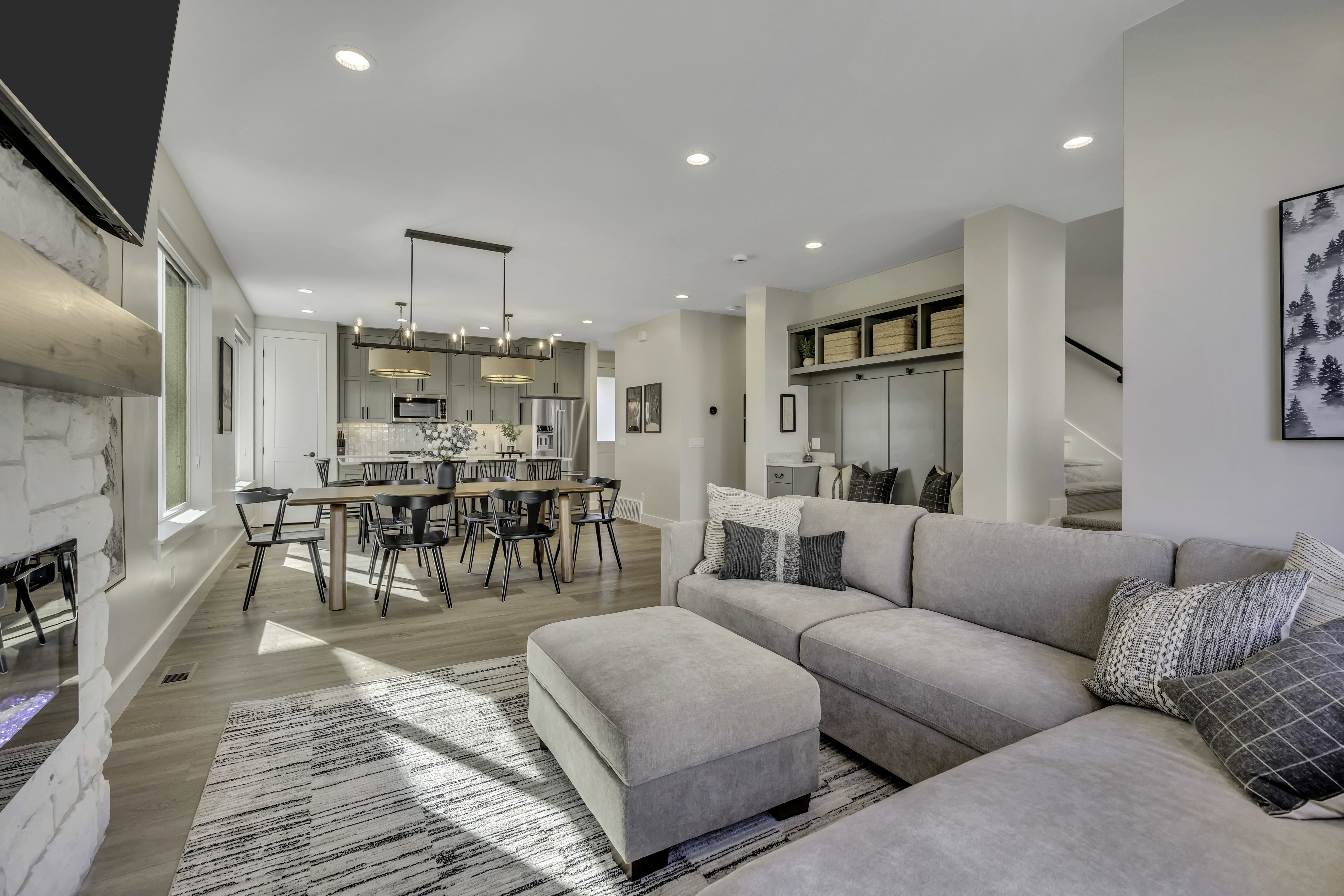 Living room featuring light wood-style floors, recessed lighting, and a stone fireplace