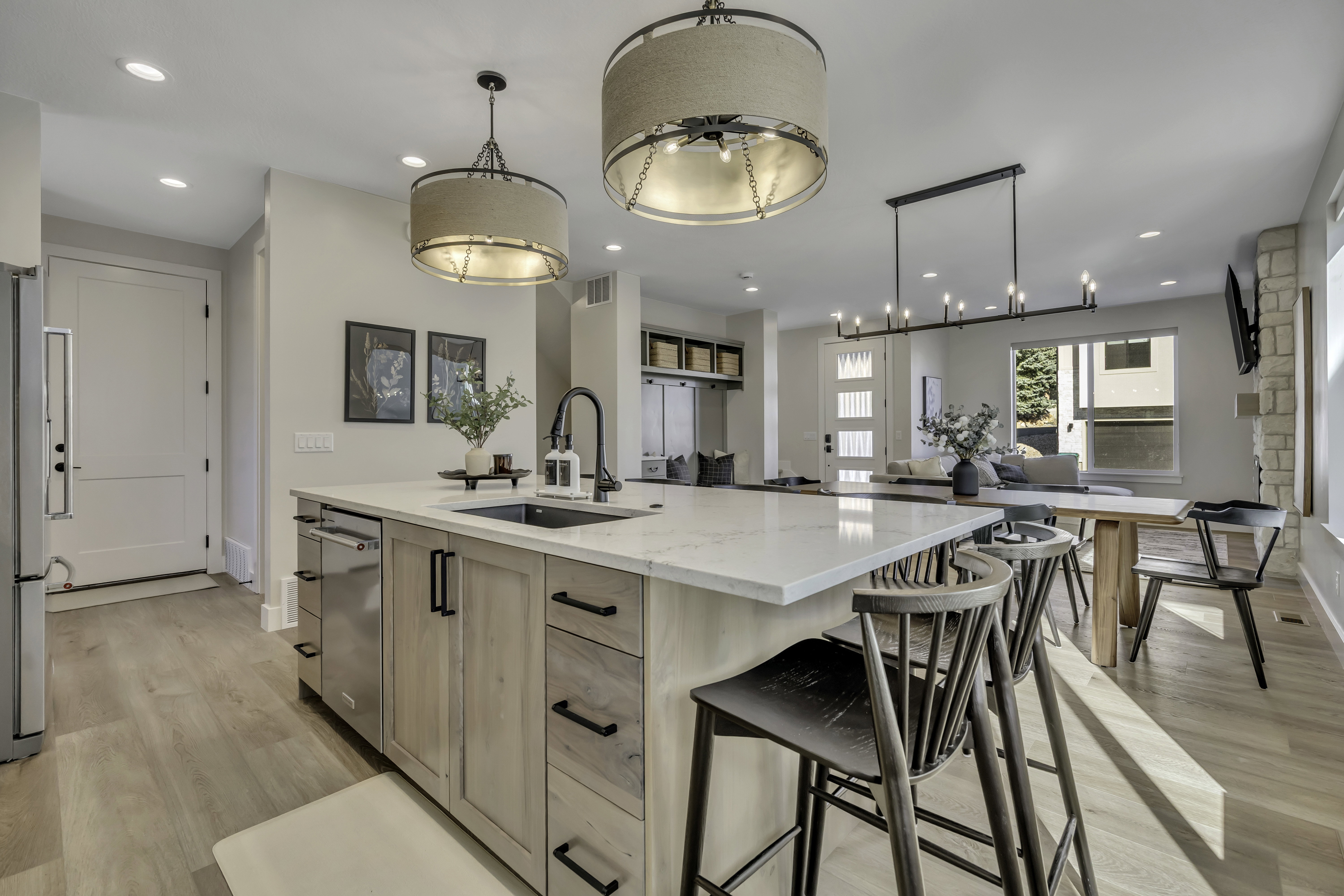 Kitchen featuring light wood-type flooring, light wood finish cabinetry, light stone counters, a spacious island, and open floor plan
